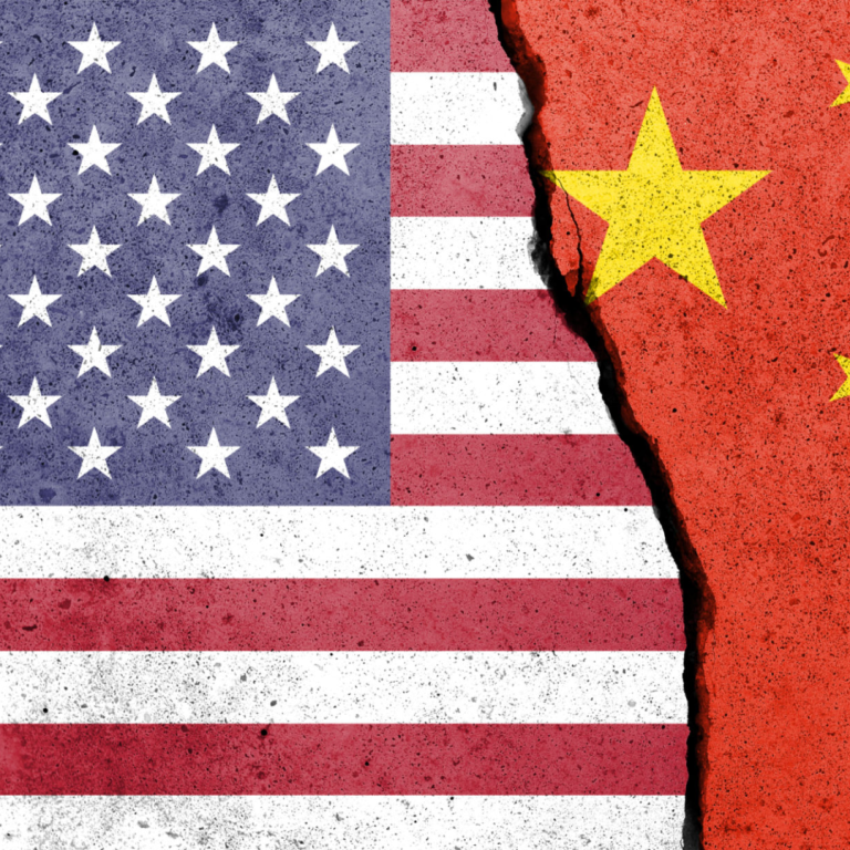 Torn flags of the USA and China representing conflict or rivalry.