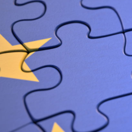 Blue puzzle piece with a yellow European Union star pattern.